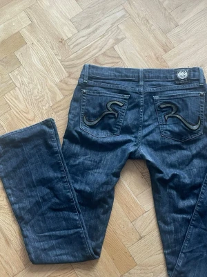 Lågmidjade jeans  - Så snygga jeans från Rock&Republic med super låg midja. Så coola detaljer!! Går ner till marken på mig som är 173! MÅTT: Midja liggandes platt: 41.5 Innerbenslängd: 83.5