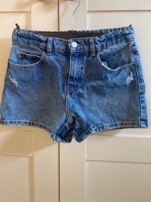 Blå jeansshorts med stjärnor där bak från Zara - Säljer ett par blå jeansshorts i storlek 148 som har normal hög midja. Shortsen har en fin passform med stjärnor på fickorna. Bara använt en enstaka gång.⭐️. 125 kr + frakt 