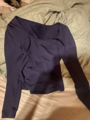 Mörkblå långärmad topp - En stilren mörkblå topp med lång ärm och rund halsringning. Toppen har en enkel och clean design som passar till många olika outfits. Materialet känns mjukt och stretchigt, vilket gör den bekväm att bära.