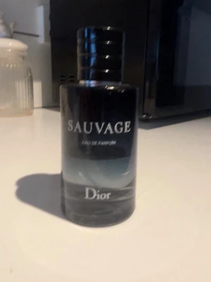 Dior Sauvage Eau de Parfum - Dior Sauvage Eau de Parfum. Plastet runt har börjat lossna lite men annars är den i bra skick. Det är ungefär 40ml kvar av hela flaskan.