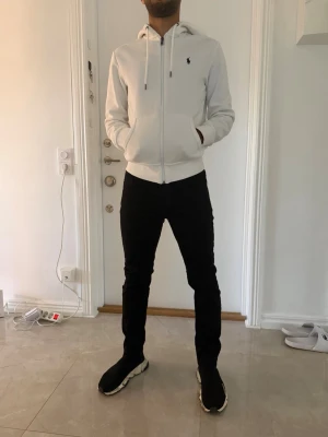 Svarta Levis slim fit jeans - Säljer ett par svarta Levis slim fit jeans med klassisk femficksdesign och normal midja. Jeansen har en stilren look och sitter tajt längs benen för en modern siluett. Perfekta för dig som gillar en enkel men snygg stil.