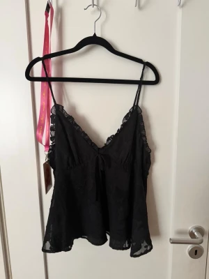 Snygg ginatricot top - Jag har haft denna i min garderob i över 1 år och jag har aldrig använt den så den säljer jag nu. Toppen är svart med ett blom mönster på i storlek 42. 