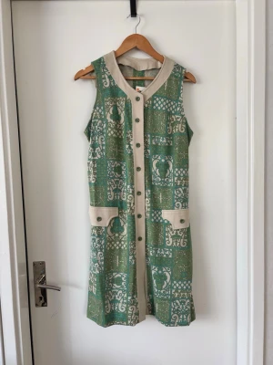 Vintage grön klänning - Vintage klänning med mönster, storlek och märke oklart men jag är S/M i klänningar. Tyget är utvättat men helt.