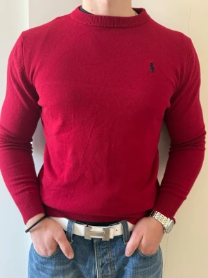Röd tröja från Polo Ralph Lauren - Klassisk röd tröja från Polo Ralph Lauren. Perfekt för avslappnad och stilren look. Storleken är 2XL men den är väldigt slim fit och sitter mer som M/L