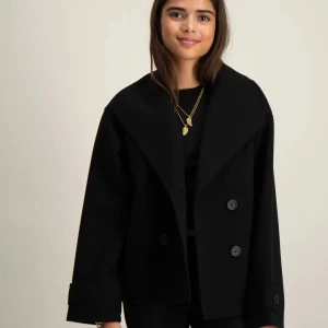 gina kappa young  - Svart kappa från gina som inte kommer till användning längre där den är lite stor 💕 skriv för fler bilder och pris kan diskuteras 