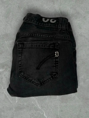 Mörkgråa  jeans från Dondup - Snygga mörkgråa jeans från Dondup med diskret tvättad look och raka ben. Klassisk femficksmodell med en liten D-detalj på bakfickan. Jeansen har normal midja och är tillverkade i ett mjukt denimtyg som ger en skön passform.