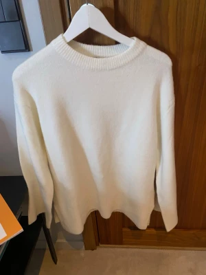 Vit stickad tröja med rund hals - Stickad vit tröja med slitningar nere på sidan från lager 157 i storlek S