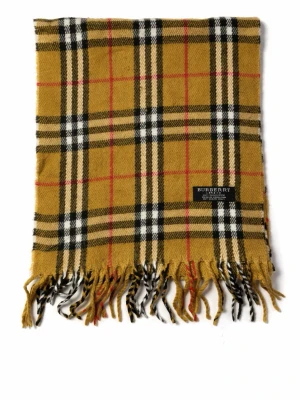 Burberry klassisk rutig halsduk - Säljer en ikonisk halsduk från Burberry i klassiskt beige, svart, vitt och rött rutmönster. Halsduken är tillverkad i 100% kashmir och har fransar i ändarna. Perfekt accessoar för att lyfta din outfit med lyxig känsla och tidlös design.