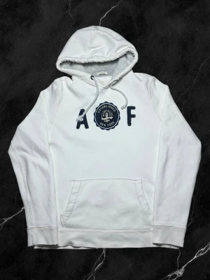 Vintage Abercrombie & Fitch hoodie - herr strl M - Säljer en vintage Abercrombie & Fitch hoodie i vit färg med brodering på bröstkorgen i storlek M med oversized passform.  👕 Märke: Abercrombie & Fitch 📏 Storlek: M, oversized 🎨 Färg: Vit 🧵 Material: 70% bomull, 30% polyester 📐 Mått: 71 cm lång, 59 cm bred 📌 Skick: Bra skick, se bilder  💬 Hör av dig vid frågor 💰 Pris kan diskuteras vid snabb affär 📦 Skickas inom 24 timmar