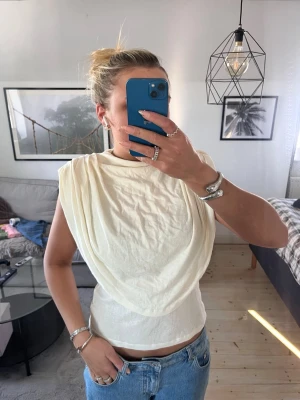 Linne/t-shirt från Gina tricot - Jättefint linne från Gina med axelvaddar! Cremefärgad!