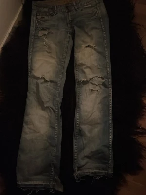 Ljusblå slitna jeans Freeman T. Porter - Säljer ett par ljusblå jeans från Freeman T. Porter med flera slitningar och hål på benen. Säljer pga försmå, rätt så tajta i storlek men de är w26💞sitter snyggt på och är straight. Köpte på Plick. Skriv vid intresse🙏