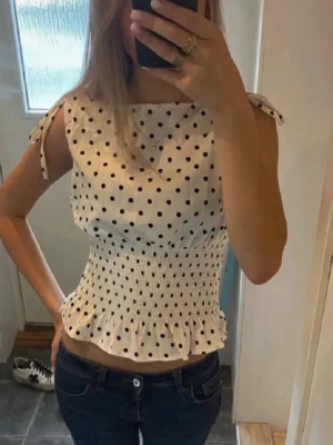 Vit prickig topp - Så fin vit topp med svarta prickar och smockad midja! Väldigt populär och helt nytt skick🩷🩷 Går inte ner i pris💞