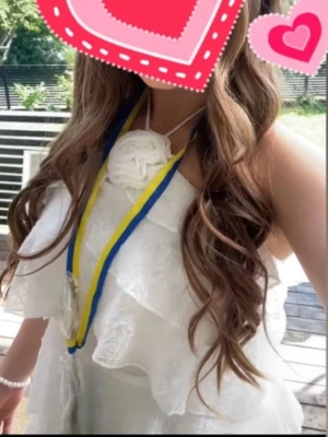 Studentklänning - Säljer en superfin vit kortklänning med volanger och halterneck. Klänningen har en stor blomdetalj framtill och är perfekt för student eller sommarens alla tillfällen. Lätt och luftig känsla med snygg passform.