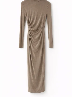 Beige långklänning med drapering - Snygg beige långklänning med lång ärm och hög hals. Klänningen har en cool drapering i sidan som ger en schysst siluett. Tillverkad i ett mjukt, stretchigt material som känns skönt mot huden. Perfekt för dig som gillar stilrena och moderna plagg.