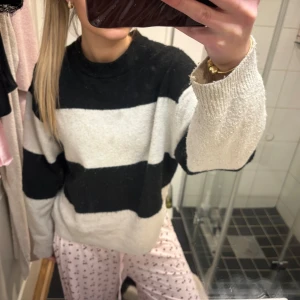 Randig oversized tröja svart/vit - Mysig oversized tröja med breda svarta och vita blockränder. Tröjan har rund halsringning och långa ärmar. Materialet ser ut att vara mjukt och fluffigt, perfekt för chill dagar hemma. Inga synliga loggor eller märken.