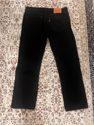 Helsvarta Levis 505 Jeans - Säljer ett par klassiska svarta jeans från Levi's med raka/baggy ben. Helt oanvända rakt ifrån zalando då storleken inte passade mig