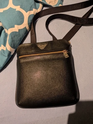 Armani Axelväska - Säljer för att jag inte använder den längre, köpt för 1700kr på Zalando. Säljer för 650, Fler bilder kan självklart fixas. Skick 9/10 inga konstigheter allt är som det ska