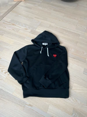 Comme de garçons hoodie - En svart tvär fet hoodie från CDGs med vita snören. Hoddie är använd fåtal gånger och är i bra skick. Storlek M och sitter bra i passformen. Modellen är 178 och väger 70kg. !!pris kan diskuteras!!