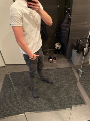 Vit pikétröja med krage - Klassisk vit pikétröja med krage och korta ärmar. Tröjan har en enkel och stilren design utan synliga loggor eller mönster. Perfekt till jeans eller shorts för en clean look.