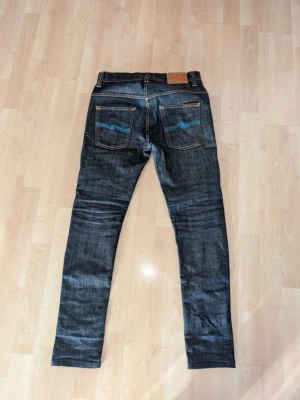 Mörkblå jeans från Nudie Jeans - Säljer ett par mörkblå jeans från Nudie Jeans i storlek 29/32 i otroligt bra skick.