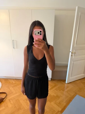 Svarta pyjamasshorts med snörning - Säljer ett par svarta shorts med elastisk midja och snörning framtill. De har en loose passform. Materialet känns mjukt och lätt😊