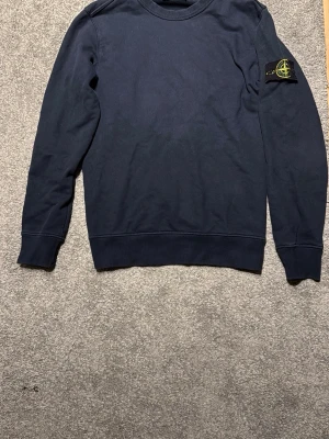 Mörkblå sweatshirt från Stone Island - Tjena🔥, Säljer en mörkblå sweatshirt från Stone Island. Har använts ett får tal gånger, men skicket är jätte bra. Nypris ligger på 2500kr. Den är också äkta som ni ser på sista bilden. Pris kan sänkas vid snabbaffär , bara att höra av sig vid frågor 