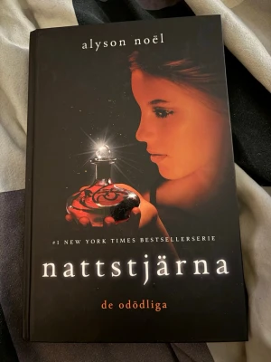 Nattstjärna av Alyson Noël - Nattstjärna är den femte delen i serien De odödliga av Alyson Noël. Omslaget är svart med en mystisk illustration av en tjej som håller en glödande flaska. Boken är inbunden och har ett lockande, magiskt tema som passar dig som gillar fantasy och romantik.