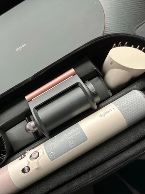 Dyson Airwrap multistyler i etui - Säljer en helt ny  Dyson Airwrap multistyler i beige och roséguld med flera stylingtillbehör. Kommer i ett snyggt hårt fodral med magnetlås. Perfekt för att skapa lockar, volym och släta frisyrer. Inkluderar borsthuvuden och stylingcylindrar.