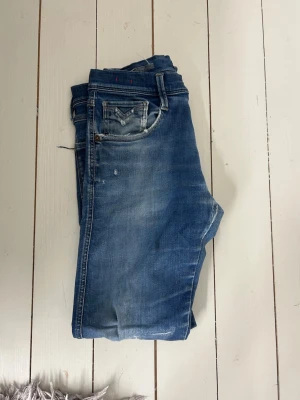 Replay jeans - Säljer ett par gamla replay hyperflex jeans. Skicket är okej. Har lagning på ena knäet och ett hål på andra. Annars snygg färg och bra jeans för sommaren. Skriv om ni har fler frågor😃