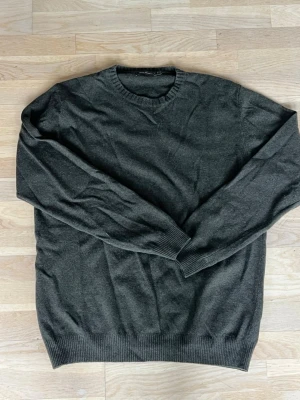 Oscar Jabcobsson sweatshirt - En enkel och stilren mörkgrön stickad tröja med rund halsringning och ribbade muddar vid ärmslut och nederkant. Perfekt basplagg i garderoben och passar till det mesta. Storleken är Large. 