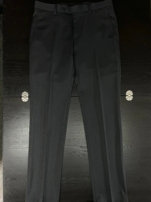 Kostymbyxor W30 L32 - Mörkgråa kostymbyxor fran dressman, storlek W30 L32 slim-fit. Mycket bra skick