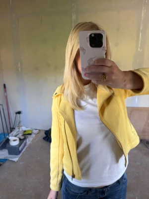 Gul jacka med dragkedjor - Snygg gul jacka i bikerstil med silvriga dragkedjor framtill och på fickorna. Jackan har bred krage med tryckknapp och figurnära passform. Perfekt för dig som vill sticka ut med färg och stil. Den är i barnstorlek men har själv kunnat använda den🩷 Den ger en färgtuch till outfiten och har en fantastiskt fin färg💛🌸