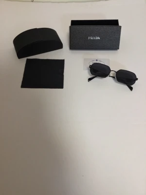 Prada Glasögon - Säljer Prada Glasögon som är tväär snygga och passar perfekt till sommaren!