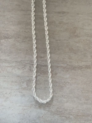 Cordell halsband  - Snyggt halsband i silverfärg med tvinnad kedja som ger en cool och glittrig look. Perfekt accessoar för att lyfta din outfit med en stilren touch. Halsbandet har en klassisk design och passar till många olika stilar.