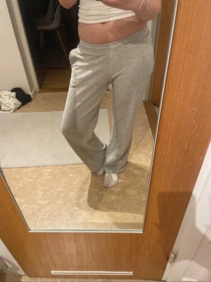 Grå mjukisbyxor med raka ben - Säljer ett par grå mjukisbyxor med raka ben och resår i midjan. Byxorna har en avslappnad passform och är perfekta för chill dagar hemma. Tillverkade i mjukt och bekvämt material som känns skönt mot huden.