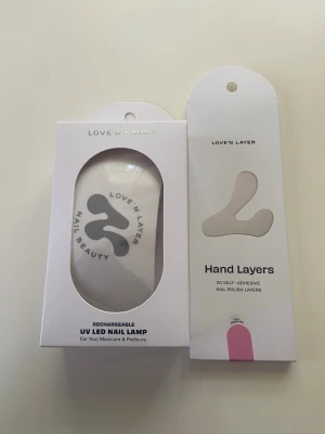 Love'n Layer Hand Layers nagellack & UV lampa  - Love and later UV lampa till naglar & Love'n Layer Hand Layers självhäftande nagellack i lager, 20 stycken i förpackningen. Färgen är en mjuk rosa nyans. Perfekt för dig som vill ha snygga naglar snabbt och enkelt utan kladd. Kommer i en stilren vit förpackning. 