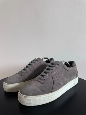 Grå Axel Arigatos - Snygga sneakers från Axel Arigato. Klassisk låg modell med enkel design som passar till det mesta. Perfekta för dig som gillar en clean och minimalistisk look.