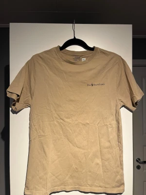 Beige t-shirt från Polo Ralph Lauren - Snygg beige t-shirt från Polo Ralph Lauren med klassisk logga tryckt på bröstet. T-shirten har rund halsringning och korta ärmar. Perfekt basplagg i mjuk bomull som passar till allt.           Jag kan förhandla priset.