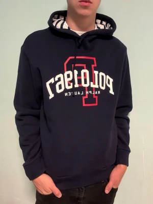 Marinblå Ralph Lauren hoodie – M - Säljer en klassisk Marinblå hoodie från Ralph Lauren i storlek M. Bekväm och tidlös modell som passar perfekt till vardags. I mycket fint skick.  Har du frågor? Tveka inte att höra av dig. Allt gott från Deluxe garderoben ⭐️ 