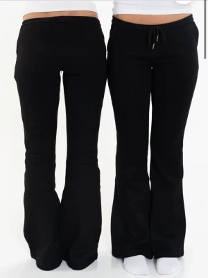 Svarta bootcut mjukisbyxor - Säljer ett par slutsålda svarta Nitted mjukisbyxor med bootcut-modell. Storlek M men sitter som xs-s. Byxorna har en klassisk passform med utsvängda ben och är perfekta för en avslappnad stil. Tillverkade i mjukt och stretchigt material för extra komfort.