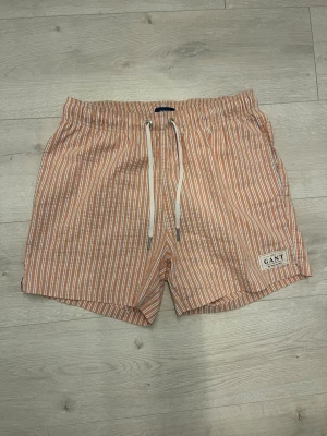 Badbyxor/shorts gant  - Säljer ett par stilrena randiga badbyxor från GANT i mycket fint skick. Perfekta för stranden, poolen eller semestern.  • Storlek: S • Färg/Mönster: Randiga • Skick: Mycket fint skick • Bekväma och snabbtorkande • Klassisk och tidlös design • Perfekta inför sommaren