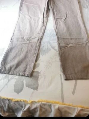 Beige linnebyxor med raka ben - Säljer ett par stilrena beige linnebyxor med raka ben och enkel design. Byxorna har en avslappnad passform och är perfekta för en chill och trendig look. Tillverkade i ett lätt och luftigt linnematerial som passar bra till varmare dagar.