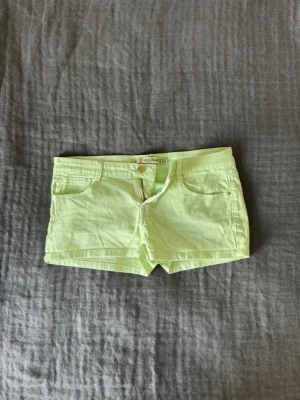 Ljusgröna shorts från Zara - Snygga neon gröna shorts från Zara med klassisk låg midja. De är korta och har en snygg passform som sitter tajt. Perfekta för sommaren och lätta att matcha med olika toppar.