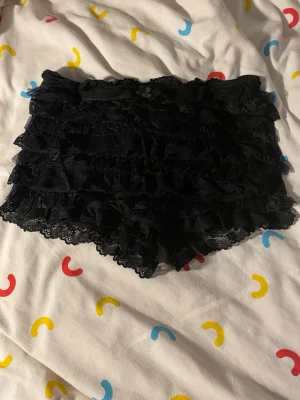 Svarta bloomer shorts med spets - Svarta bloomers/shorts med spets och volanger. Endast provade men aldrig använt.