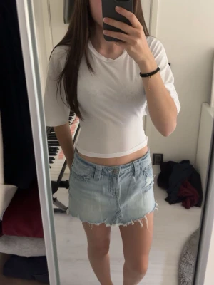 Vit topp med knyt i ryggen - Säljer en vit topp med halvlånga ärmar och snygg knytning i ryggen. Toppen har en enkel och clean look, perfekt till jeans eller kjol. Materialet känns otroligt mjukt och härligt mot huden.