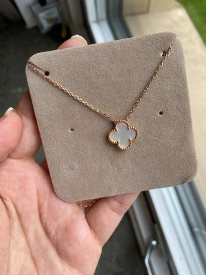 18 k guldpläterad halsband, hög kvalitet get inte allergi  - Du kanske tycker att det är dyrt men den är värt för den fina kvaliten och fina äkta snäckskalen den har. Snyggt halsband i guldton med ett fyrklöverformat hänge i vit pärlemor. Hänget har en dekorativ kant och kedjan är tunn och elegant. Perfekt för dig som gillar stilrena och trendiga smycken med en touch av lyx. Örhängen säljs separat 