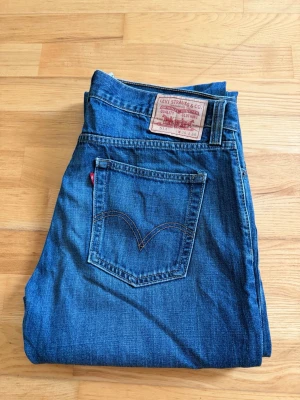 Levi's 514 Slim Straight jeans blå - Säljer ett par klassiska Levi's 514 Slim Straight jeans i blå denim. Jeansen har rak passform, fem fickor och den ikoniska röda Levi's-lappen på bakfickan. Perfekta för en clean och tidlös look. Materialet är slitstark bomullsdenim.