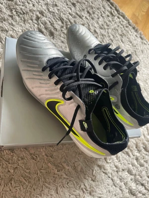  Fotbollskor. Nike Tiempo Elite AG  - Nike tiempo fotbollskor, modellen Elite AG(konstgräs). Storlek 41. de är i bra skick. Jag har själv laceat de sådär. Väldigt bekväma och sköna skor. Pris och frågor kan diskuteras.