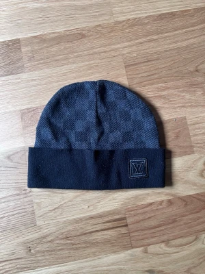 Mörkgrå/ svart mössa - Säljer en mörkgrå/ svart mössa köpt för cirka 2 år sedan. Mössan är stickad och har en klassisk, enkel form som passar till det mesta. Inga skador eller fläckar. Vid frågor så kan ni bara kontakta mig💫 pris kan diskuteras