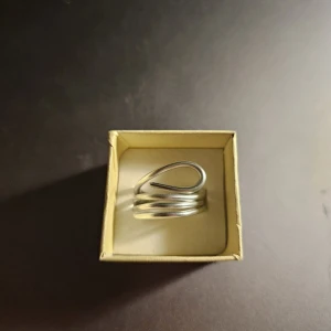 Handgjord Spiralring I Modern Design - Handgjord och unik ring i silverfärgad metall (aluminium) med spiralformad design. Ringen har flera varv som ger en chunky och edgy känsla, perfekt för dig som gillar statement-smycken. 